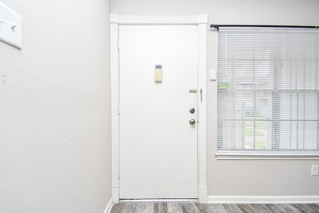 doorway with wood finished floors and baseboards