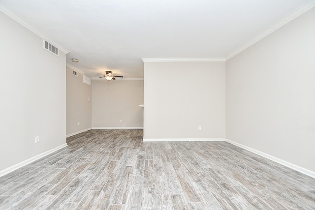 unfurnished room with visible vents, a ceiling fan, ornamental molding, wood finished floors, and baseboards