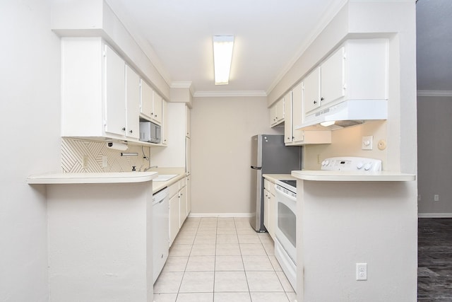 kitchen with under cabinet range hood, white appliances, crown molding, and light countertops