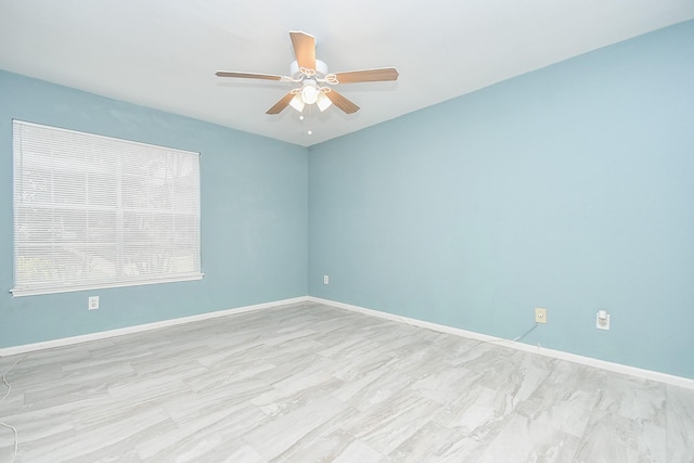 unfurnished room with ceiling fan and baseboards