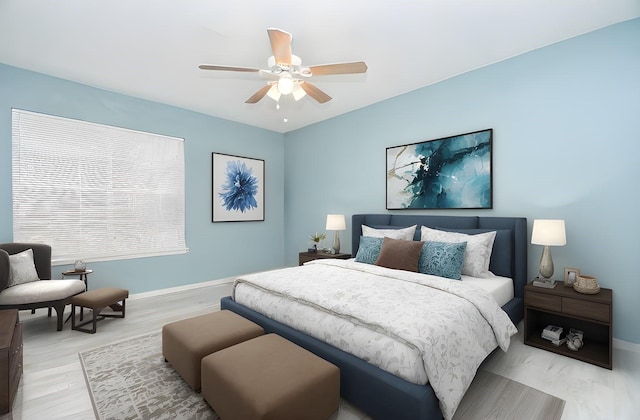 bedroom featuring light wood-style flooring, a ceiling fan, and baseboards