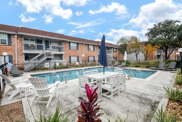 pool with a patio area and fence