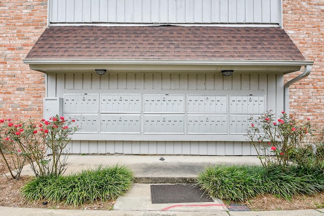 exterior space with a garage and mail area