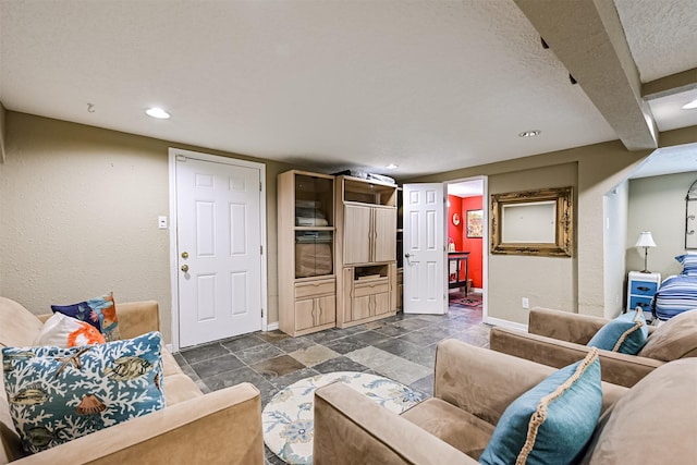 living area featuring recessed lighting, stone finish flooring, and baseboards