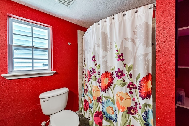 bathroom with a textured ceiling, a textured wall, curtained shower, toilet, and visible vents