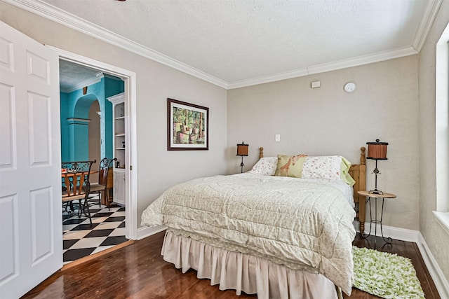 bedroom with baseboards, arched walkways, ornamental molding, dark wood-style flooring, and a textured ceiling