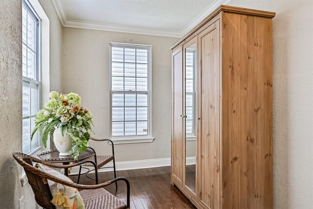 sitting room featuring plenty of natural light, ornamental molding, and dark wood-style flooring