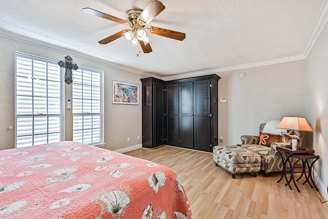 bedroom featuring a textured ceiling, ornamental molding, and light wood-style flooring