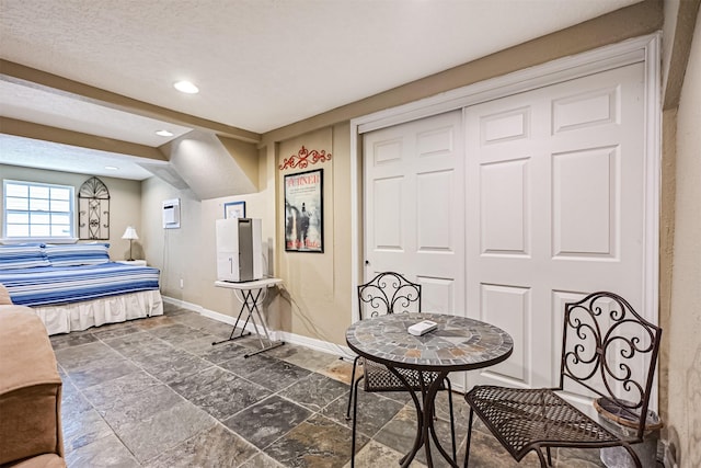 bedroom featuring a closet, recessed lighting, stone finish floor, and baseboards