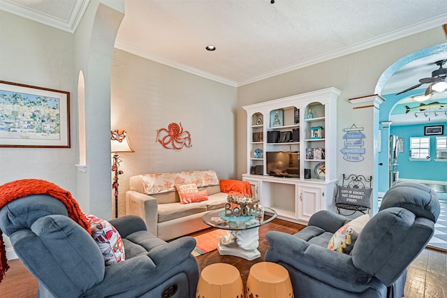 living area with crown molding, ceiling fan, and wood finished floors