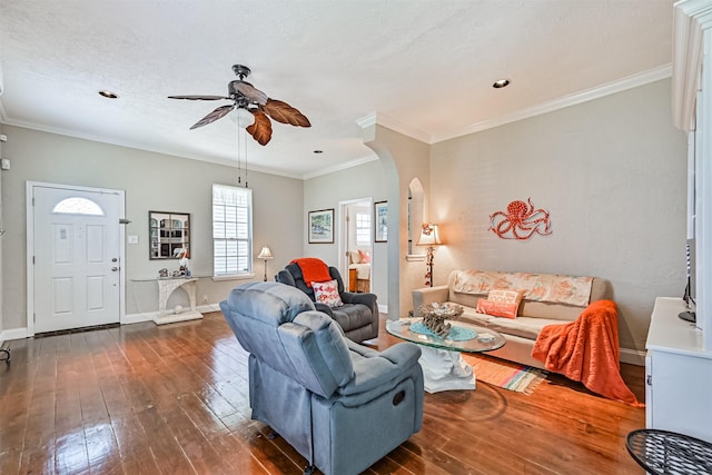 living room featuring arched walkways, ceiling fan, baseboards, ornamental molding, and hardwood / wood-style floors