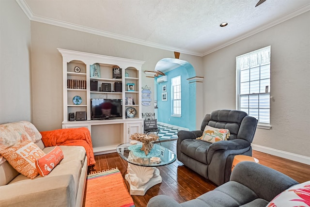 living area featuring baseboards, arched walkways, wood finished floors, and ornamental molding