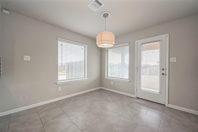 unfurnished dining area featuring light tile patterned floors, visible vents, and baseboards