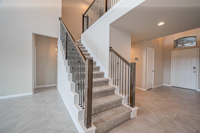 entryway with light tile patterned flooring, recessed lighting, a high ceiling, baseboards, and stairway