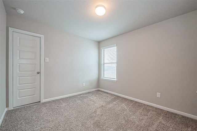 unfurnished room with carpet and baseboards