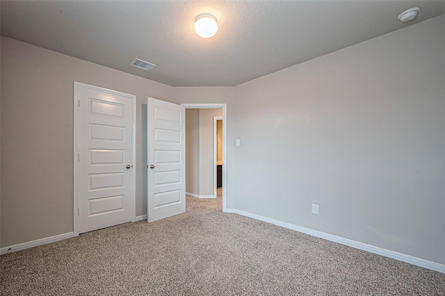 unfurnished bedroom with baseboards, visible vents, and light colored carpet