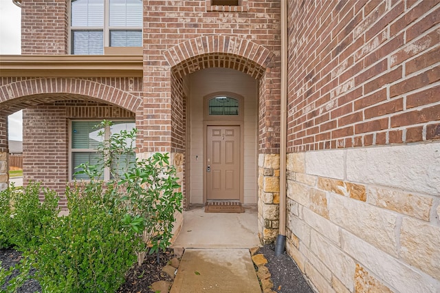 entrance to property featuring brick siding