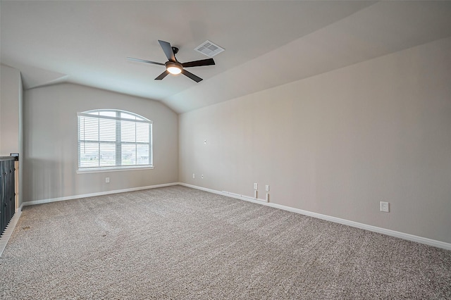 empty room featuring visible vents, a ceiling fan, light carpet, vaulted ceiling, and baseboards