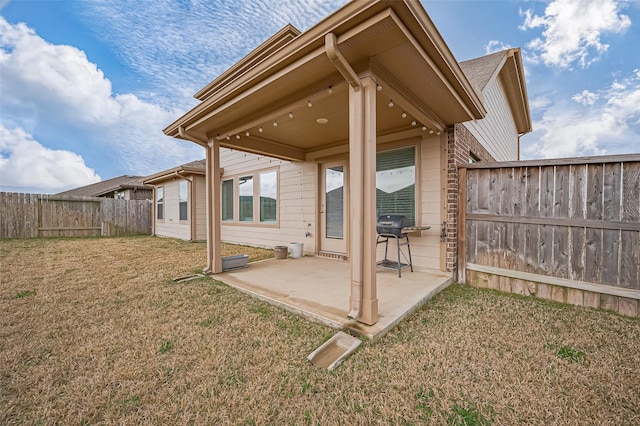 rear view of house featuring a patio area, fence, and a lawn