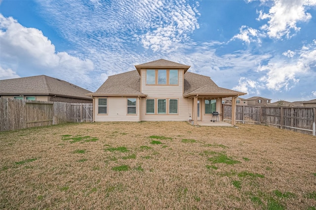 rear view of house with a yard, a patio area, and a fenced backyard