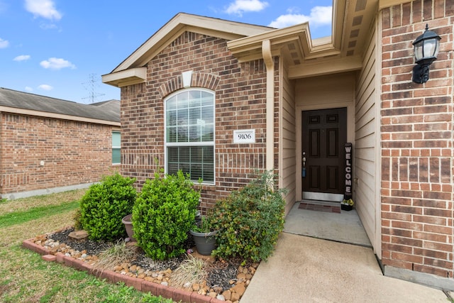 property entrance featuring brick siding