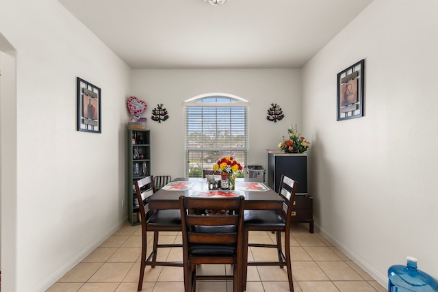 dining space featuring light tile patterned flooring and baseboards