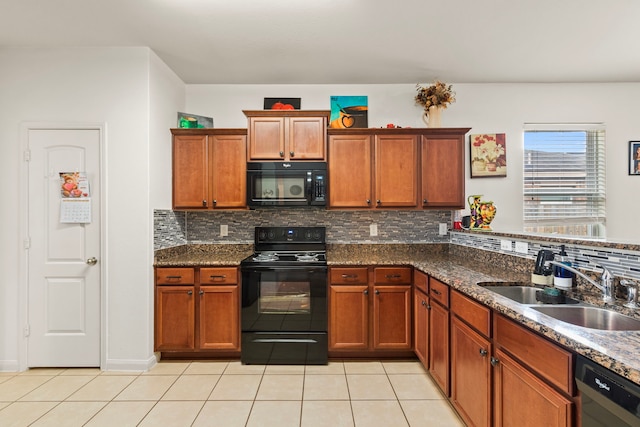 kitchen featuring black appliances, light tile patterned floors, brown cabinets, and a sink