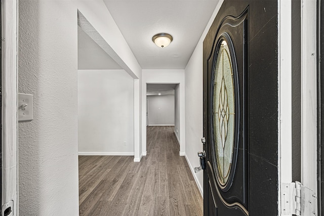 entryway featuring baseboards and wood finished floors