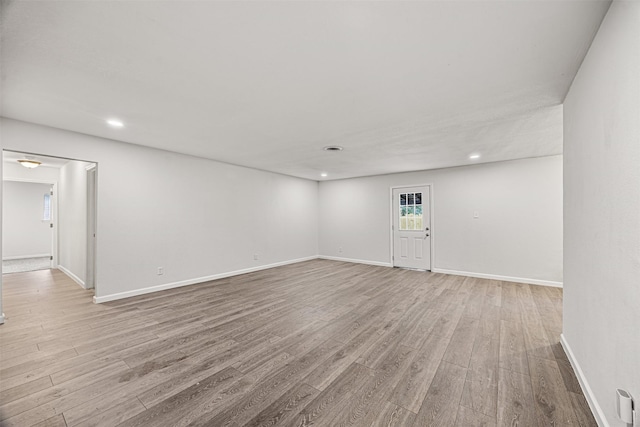 unfurnished room featuring recessed lighting, wood finished floors, and baseboards