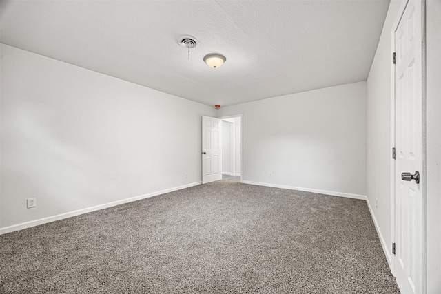 unfurnished room featuring a textured ceiling, carpet flooring, visible vents, and baseboards