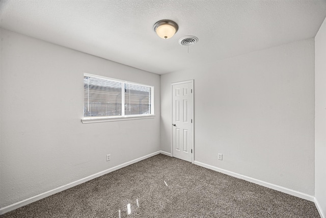 carpeted empty room featuring visible vents, baseboards, and a textured ceiling