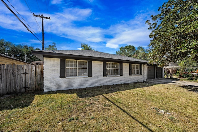 view of front of house featuring brick siding, an attached garage, fence, driveway, and a front lawn