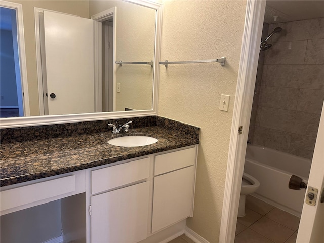 bathroom with a textured wall, toilet, shower / tub combination, tile patterned flooring, and vanity