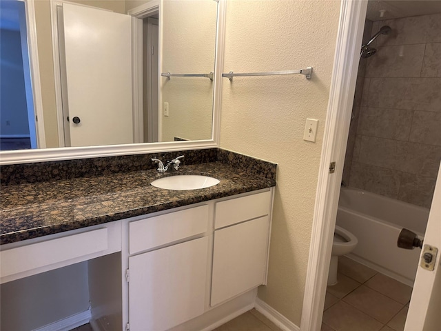 bathroom featuring toilet, a textured wall, vanity, and tile patterned floors