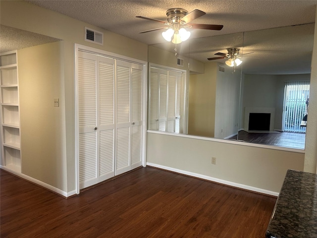 interior space with dark wood-style floors, a textured ceiling, and visible vents