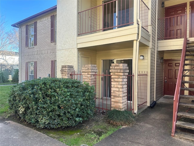 exterior space with brick siding and a balcony