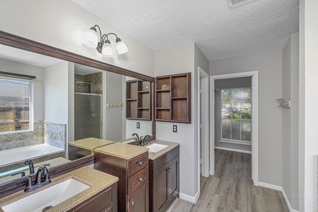 full bath featuring a textured ceiling, a stall shower, vanity, and a bath