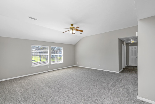 carpeted spare room with attic access, visible vents, baseboards, ceiling fan, and vaulted ceiling