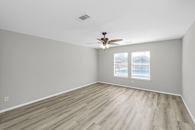 unfurnished room featuring light wood-style floors, visible vents, baseboards, and a ceiling fan