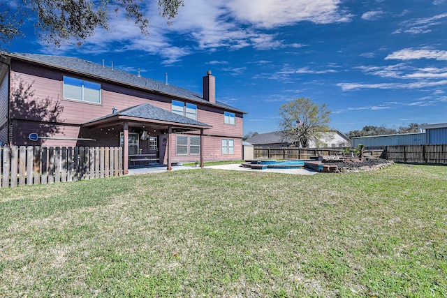 rear view of house featuring a patio, a fenced backyard, a chimney, a yard, and a gazebo