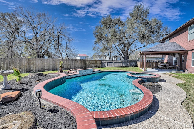 view of swimming pool with a fenced backyard, a pool with connected hot tub, and a patio