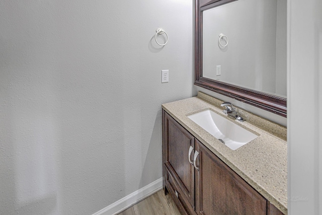 bathroom featuring vanity, baseboards, and wood finished floors