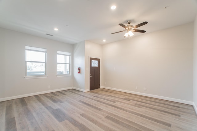 spare room featuring recessed lighting, ceiling fan, light wood-style flooring, and baseboards