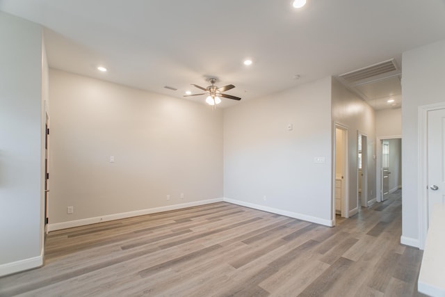 empty room featuring light wood-type flooring, attic access, visible vents, and recessed lighting