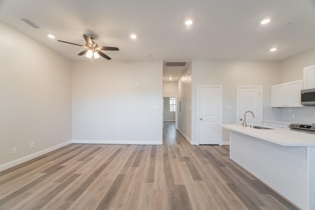 kitchen with appliances with stainless steel finishes, light countertops, a sink, and visible vents