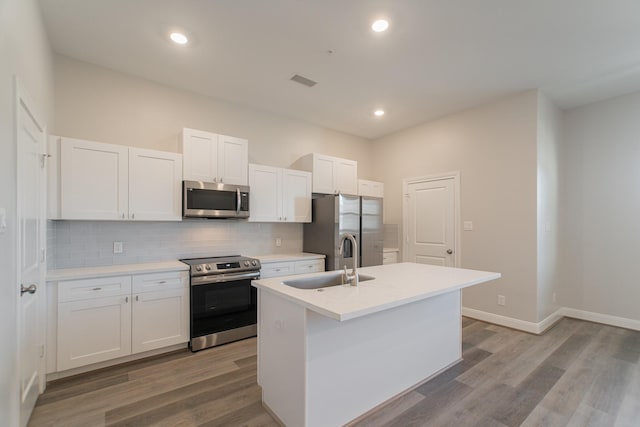 504 Nursery Rd Unit 3202, The Woodlands, TX 77380 - kitchen with stainless steel appliances, a sink, an island with sink, decorative backsplash, and white cabinetry