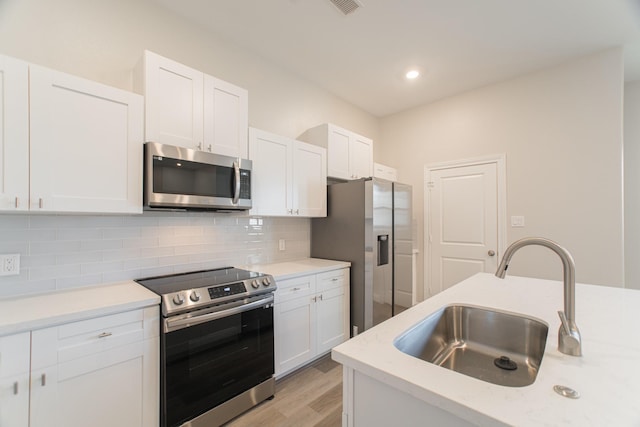 504 Nursery Rd Unit 3202, The Woodlands, TX 77380 - kitchen featuring stainless steel appliances, a sink, light countertops, white cabinetry, and recessed lighting