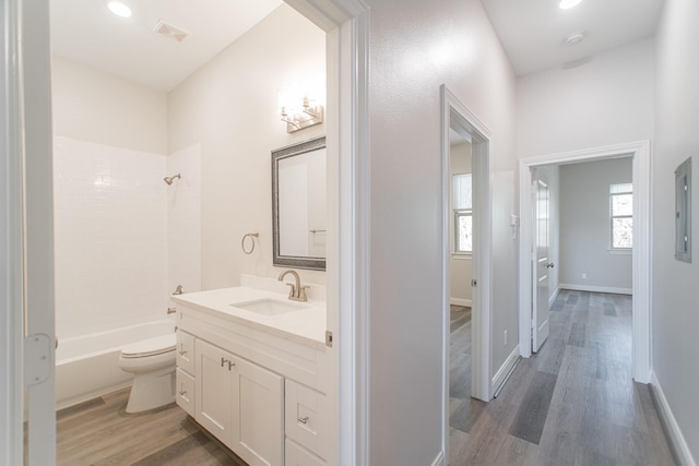 full bath featuring shower / washtub combination, visible vents, toilet, vanity, and wood finished floors