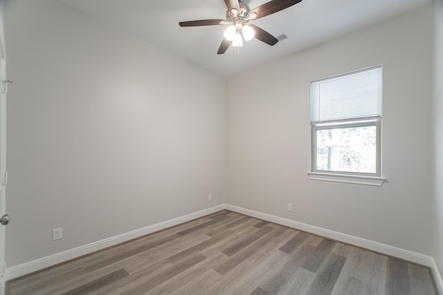 unfurnished room featuring ceiling fan, light wood-style floors, visible vents, and baseboards