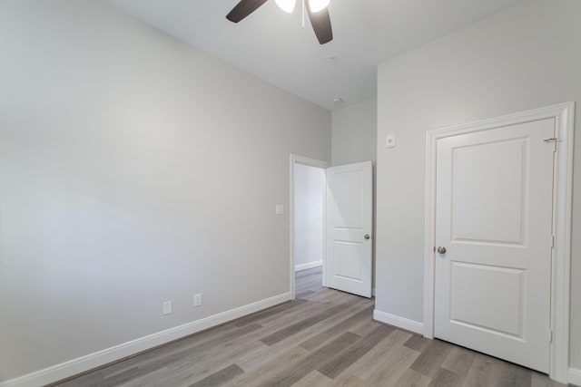 unfurnished bedroom with light wood-type flooring, baseboards, and a ceiling fan